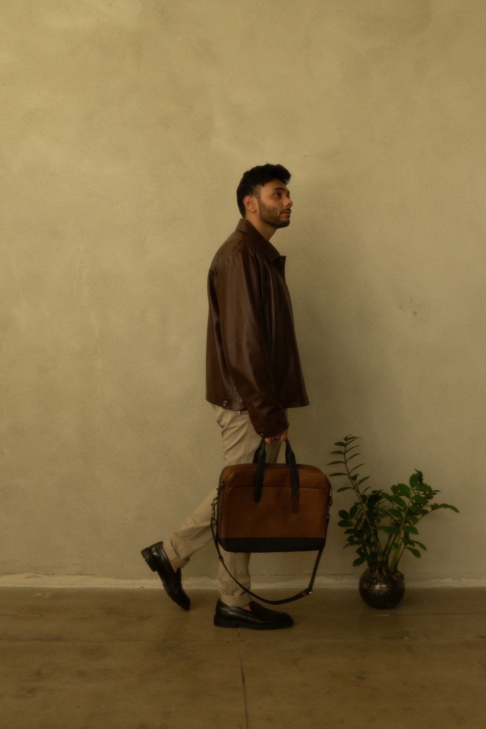 Zeek walking with a leather bag